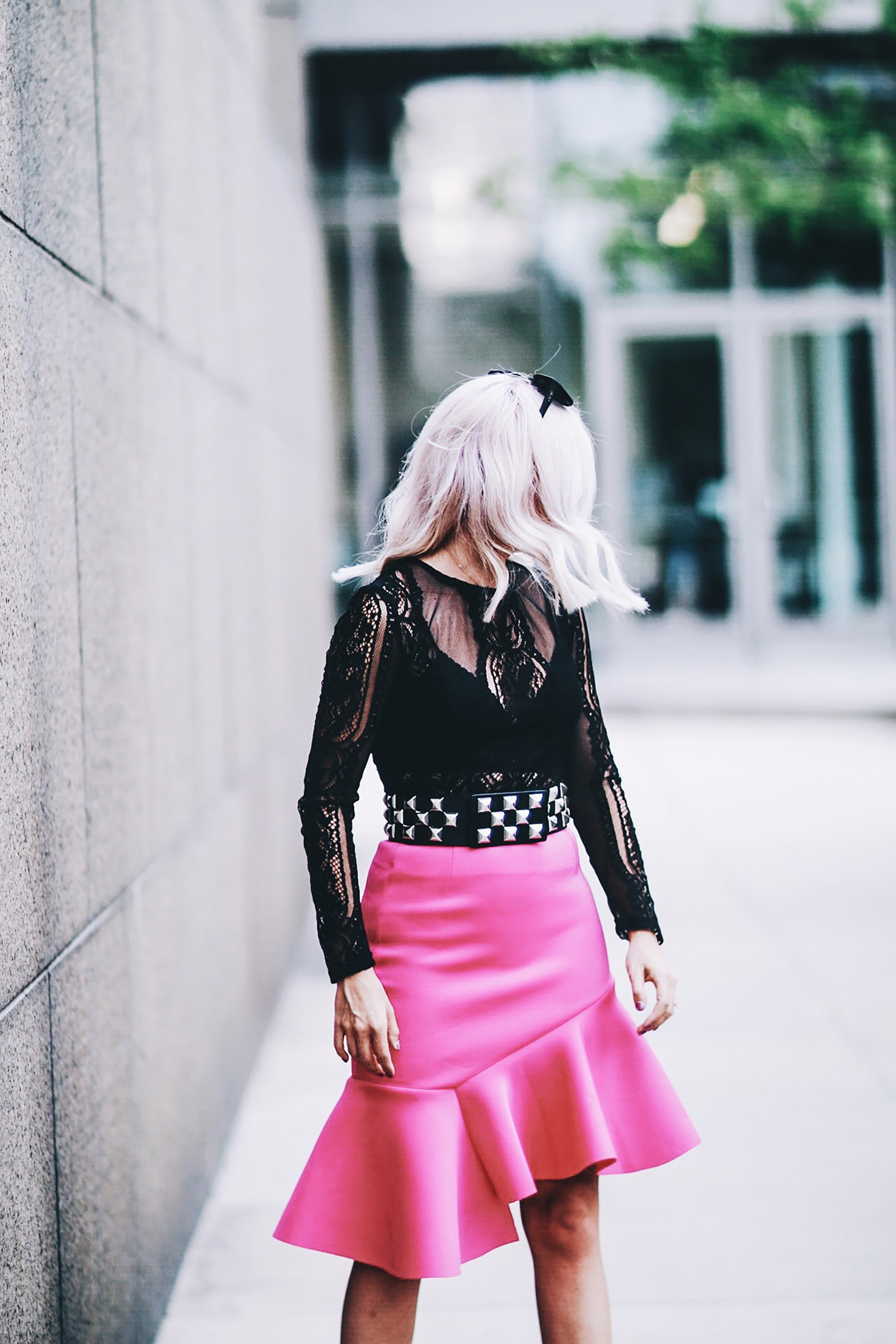 Alena Gidenko of modaprints.com styles a hot pink skirt with a long sleeve lace top, studded belt and black heels