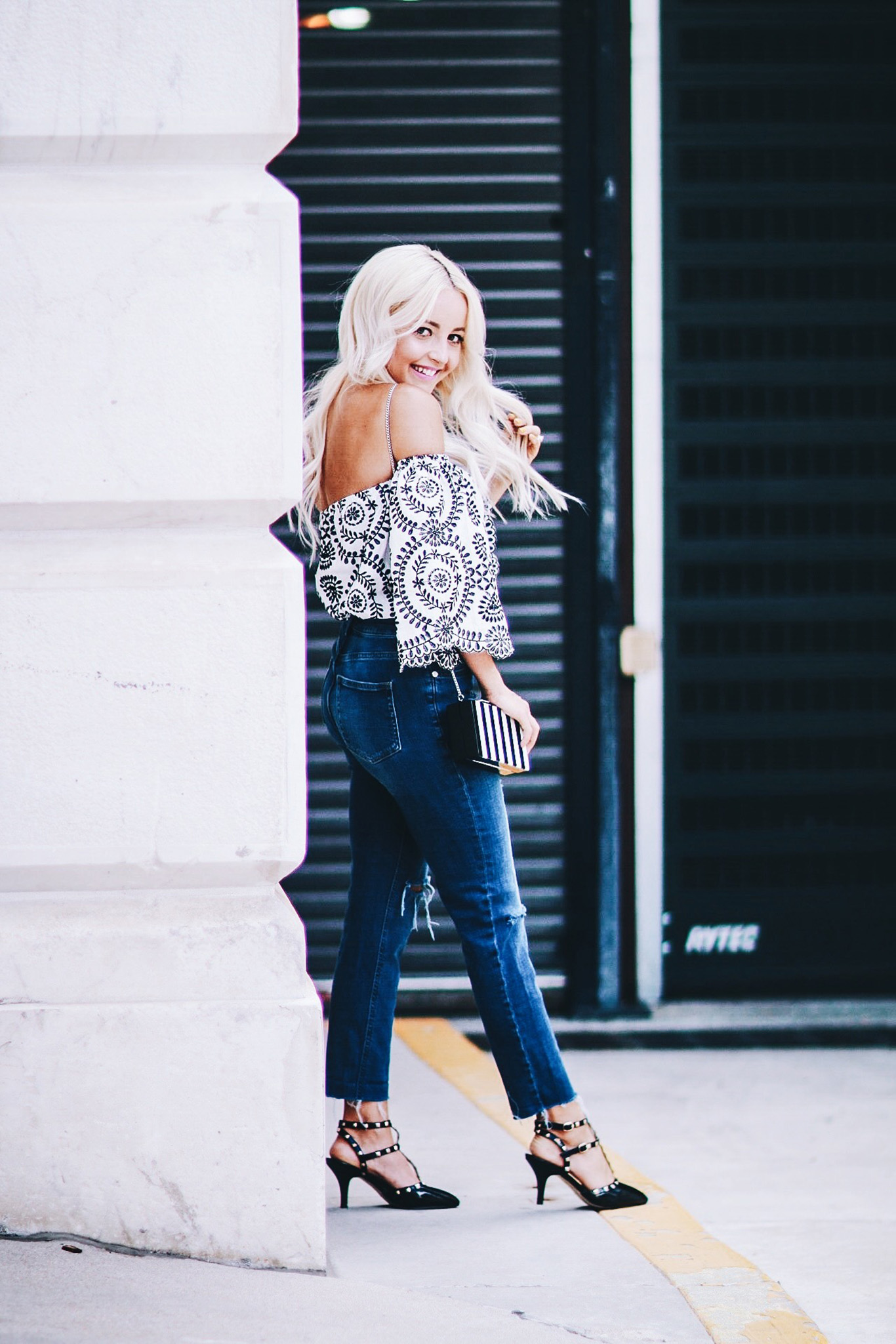 Alena Gidenko of modaprints.com styles an off the shoulder printed top with boyfriend jeans and studded black heels