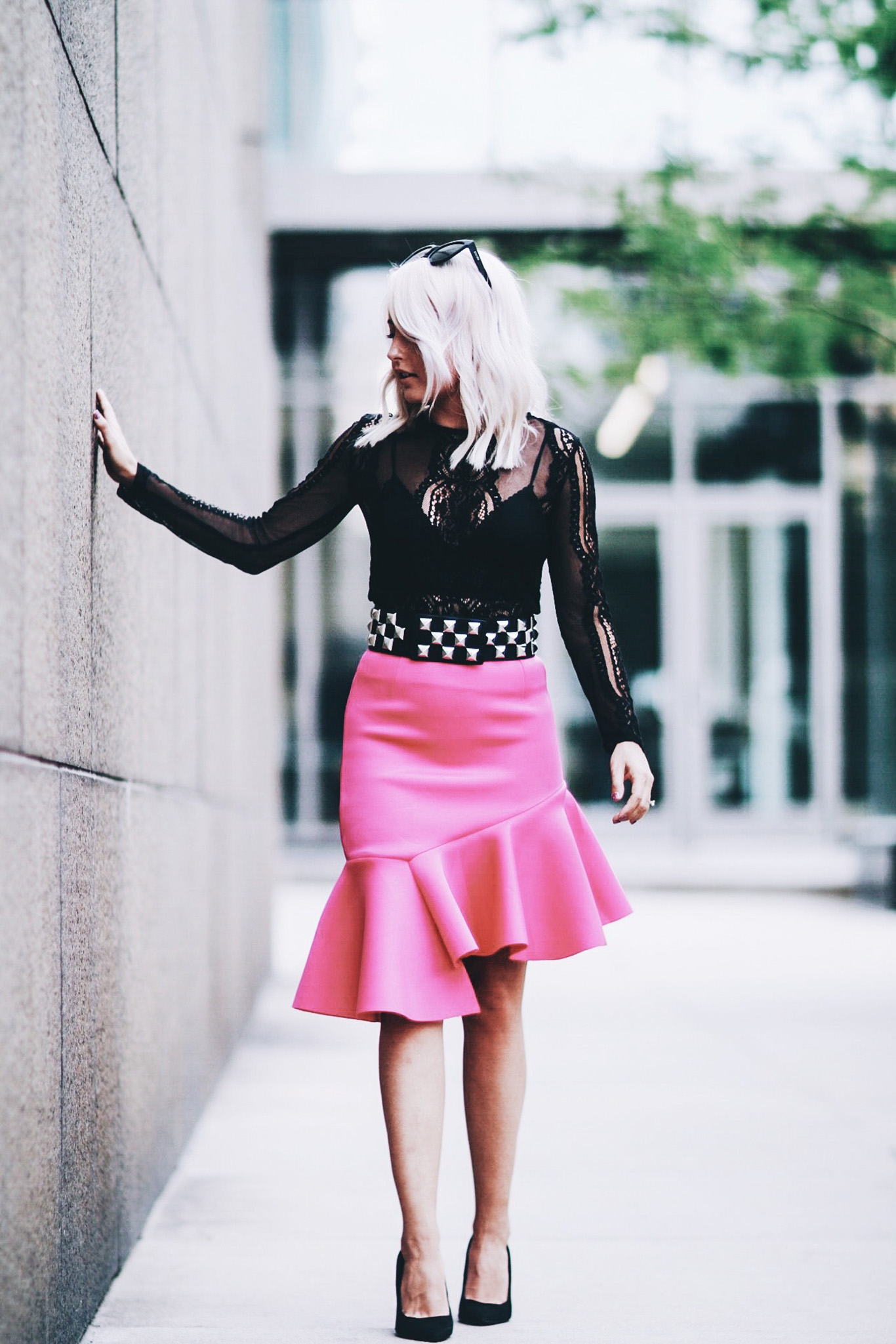 Alena Gidenko of modaprints.com styles a hot pink skirt with a long sleeve lace top, studded belt and black heels